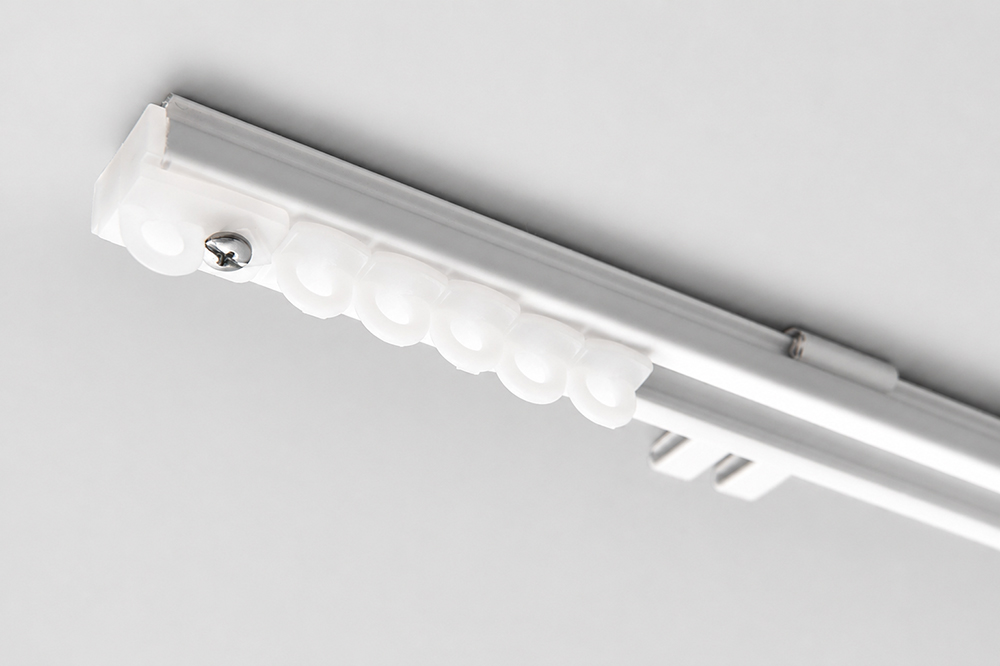 Decorquip white ceiling-mounted ACT43 curtain track with gliders in a product installation close-up