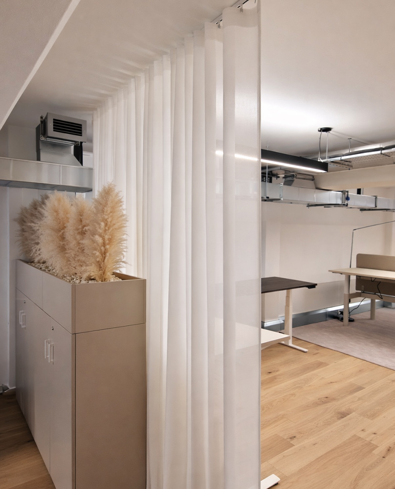 Decorquip white sheer curtain on a ceiling track dividing a modern commercial office interior