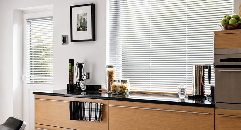 Decorquip white aluminium Venetian blinds fitted to large windows in a modern kitchen