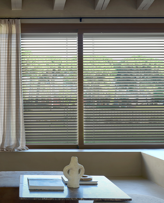 Decorquip grey aluminium Venetian blinds fitted across wide living room windows