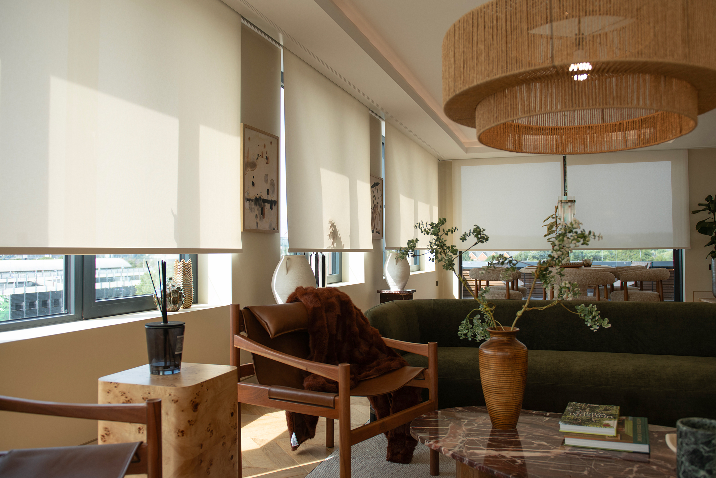 Decorquip cream roller blinds partially lowered across large living and dining room windows