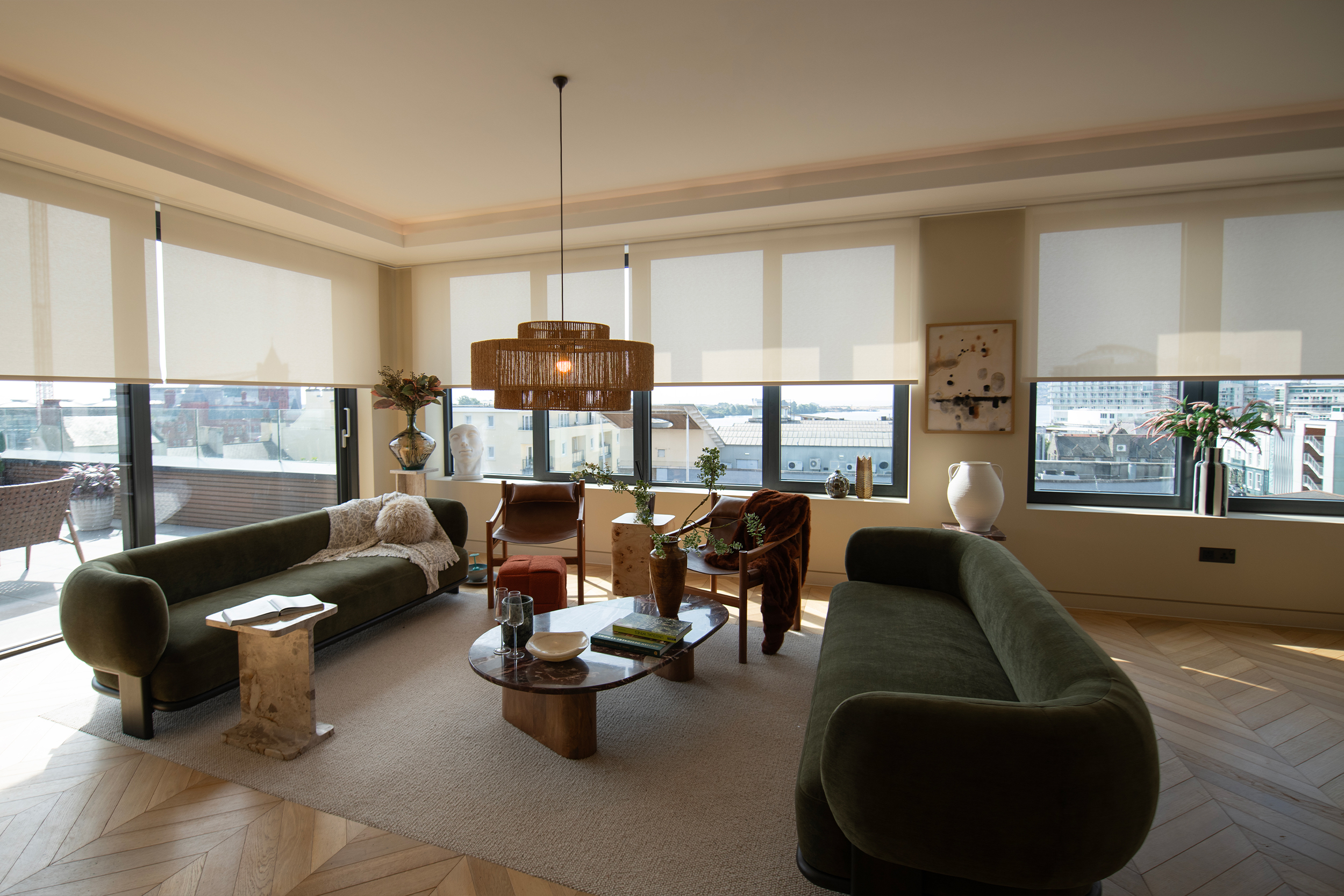 Decorquip cream roller blinds partially lowered across wide living room windows