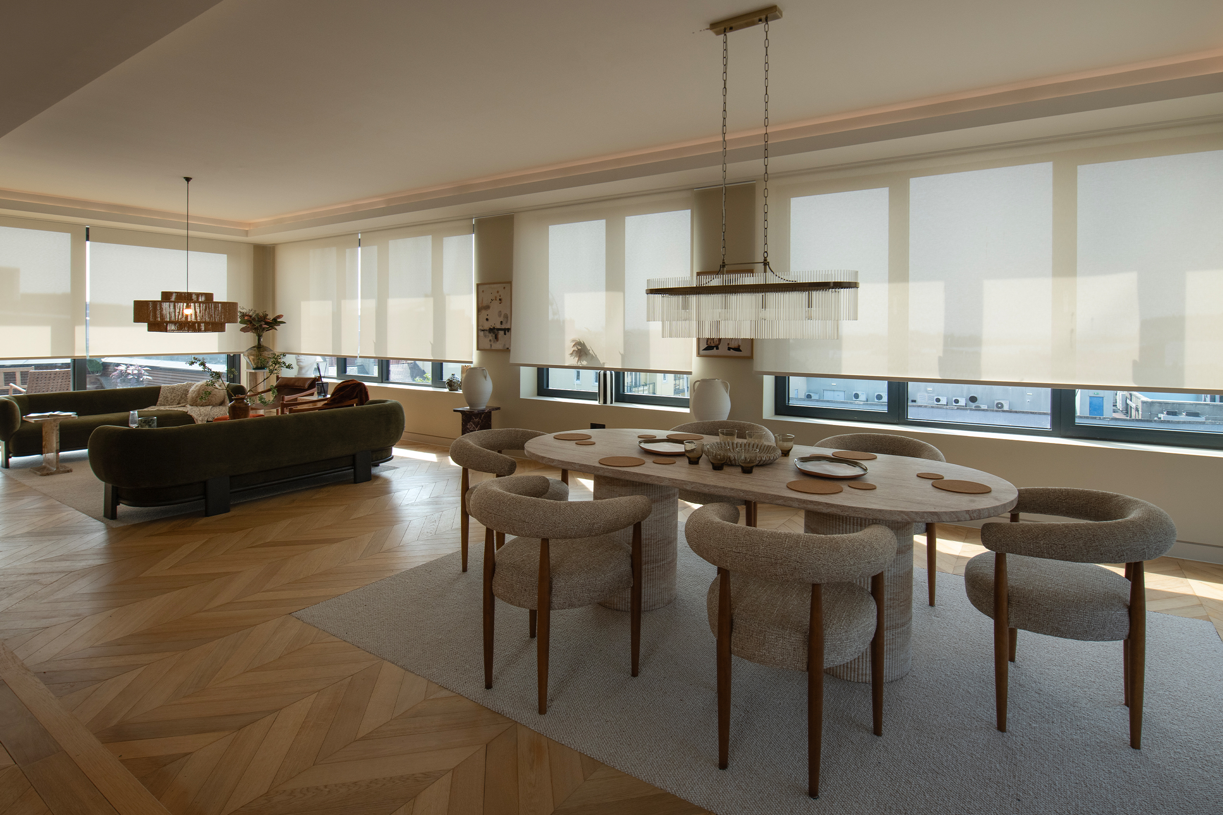Decorquip cream roller blinds partially lowered across wide living room windows