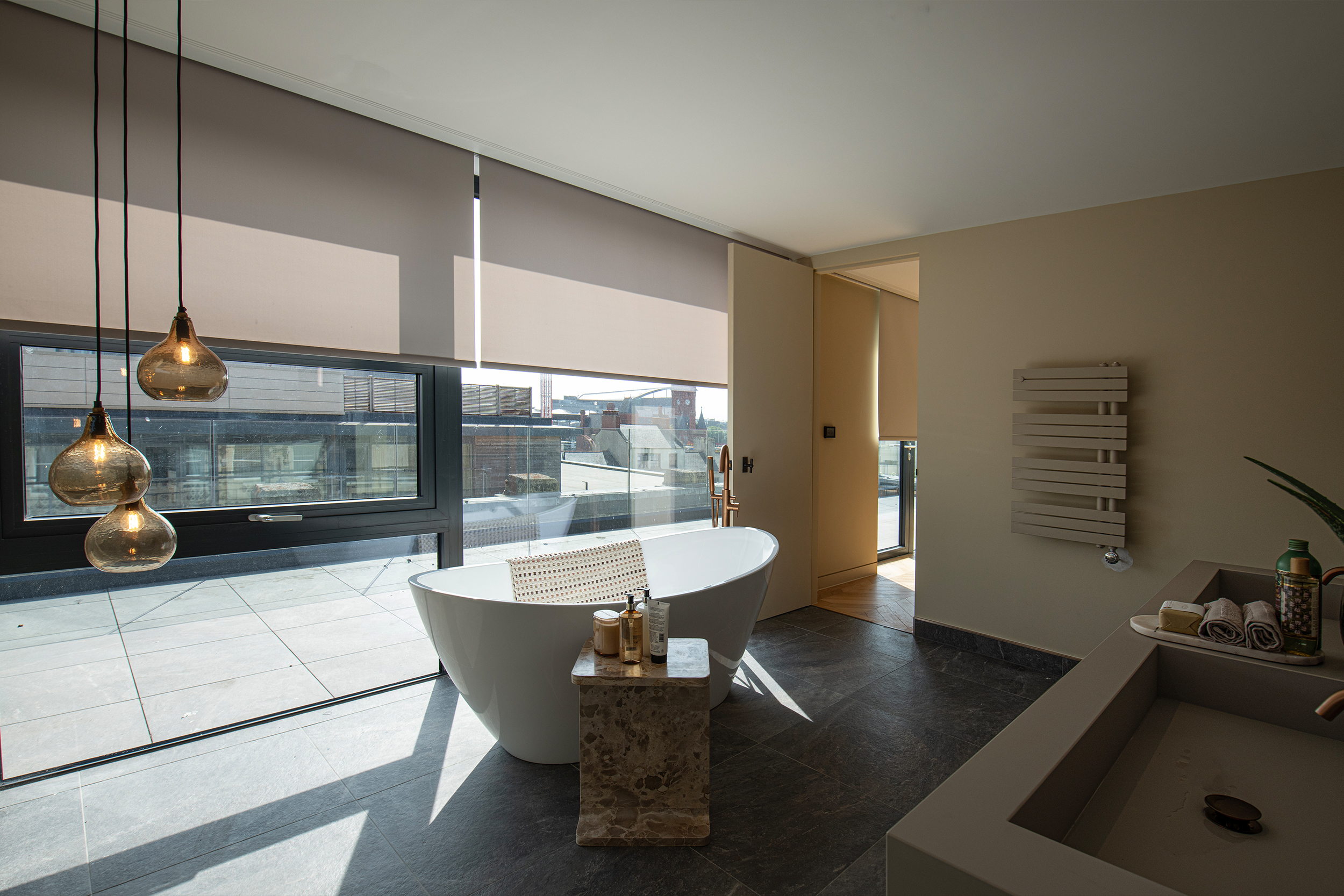 Decorquip grey roller blinds partially lowered over large bathroom windows
