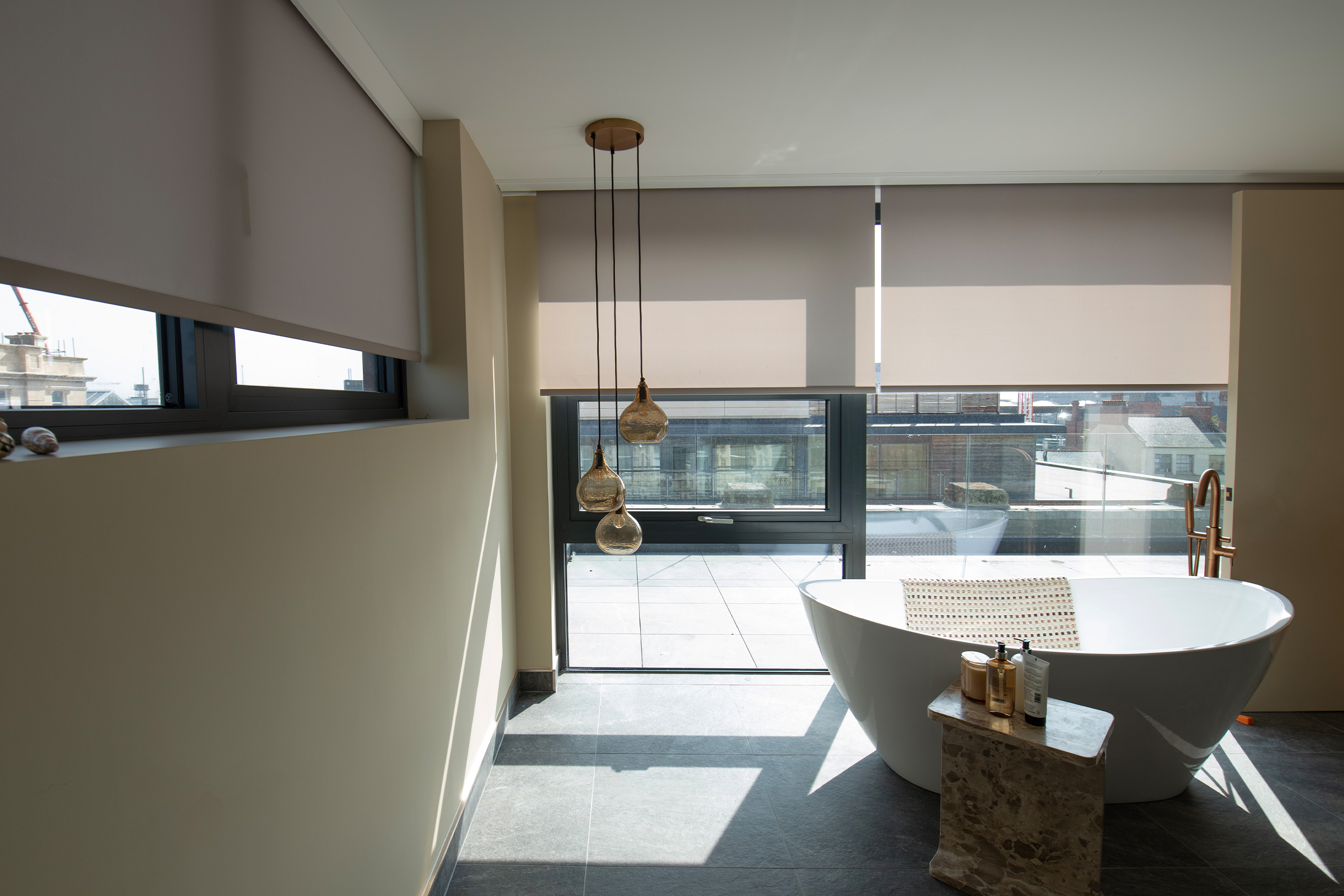 Decorquip grey roller blinds partially lowered over large bathroom windows