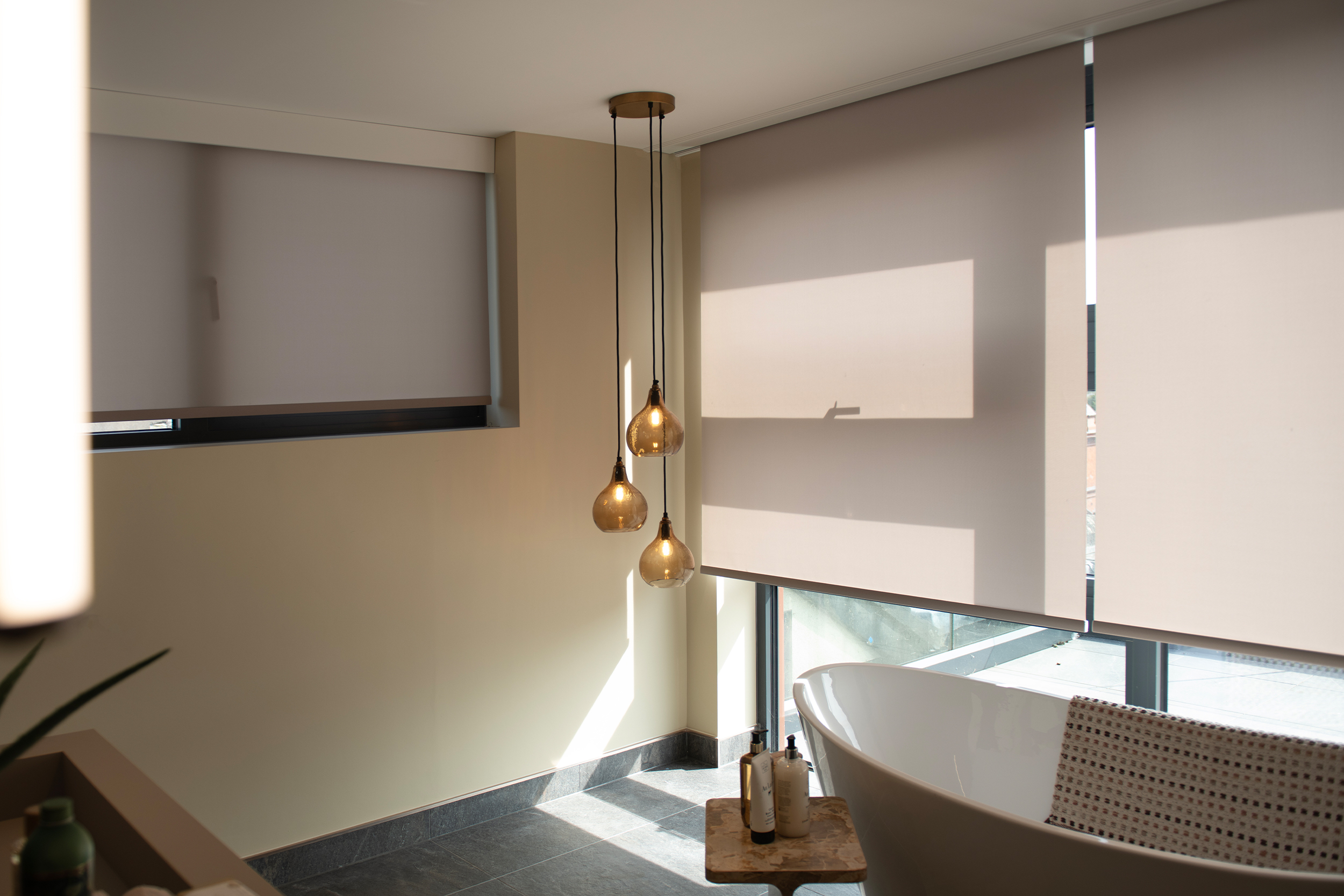Decorquip grey roller blinds partially lowered over large bathroom windows