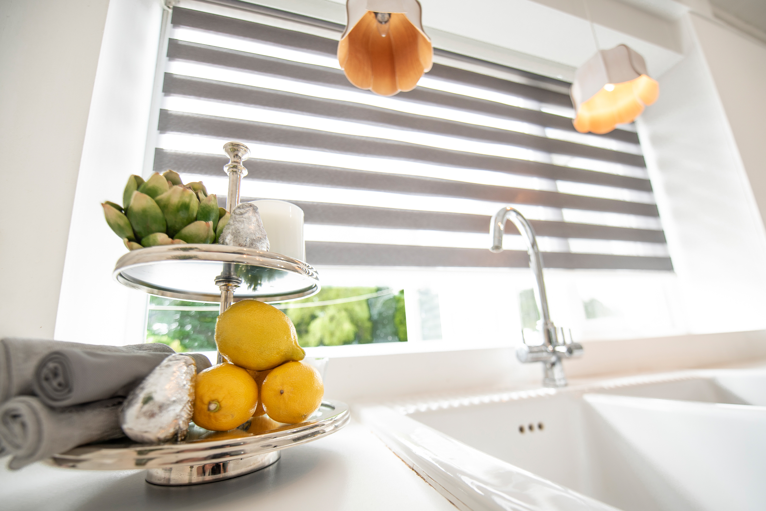 Decorquip grey day and night blind with alternating sheer panels above a white kitchen sink