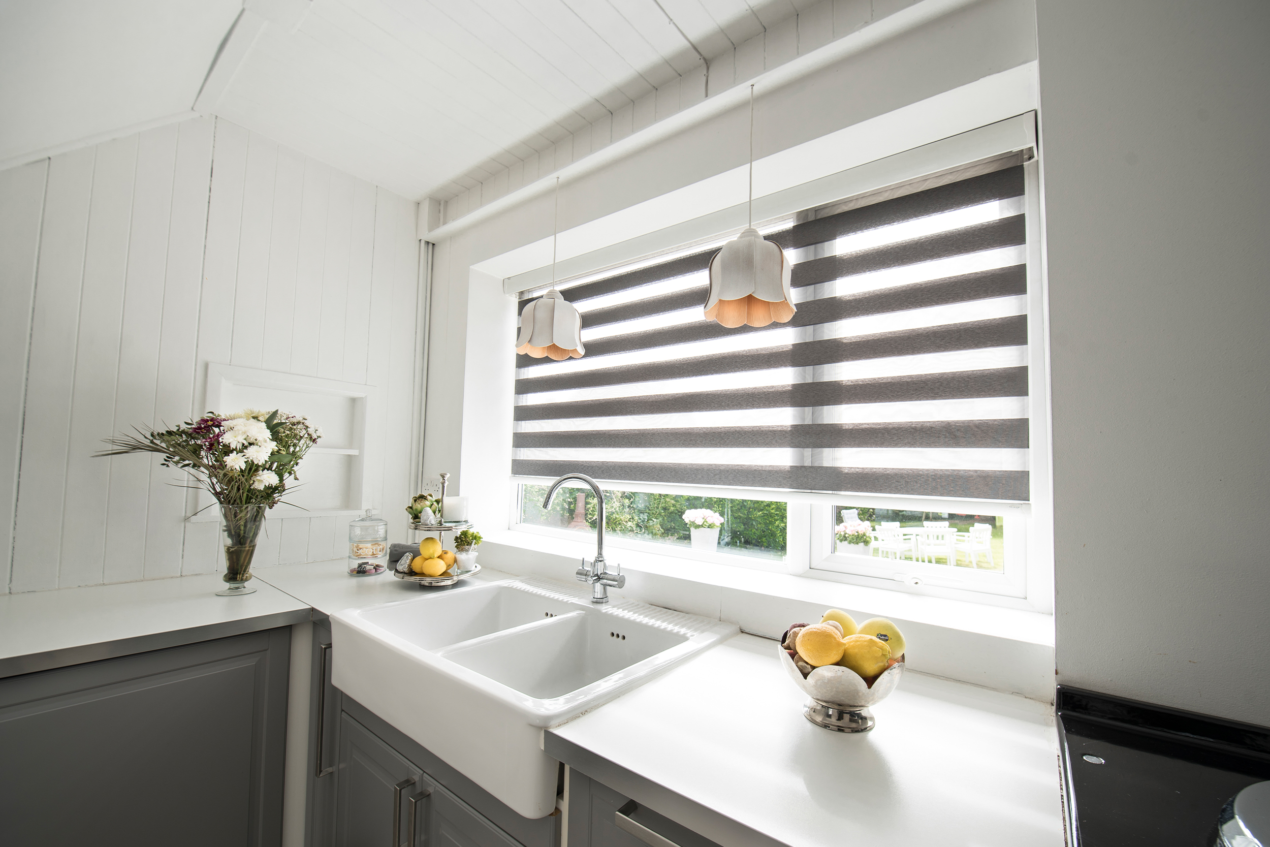 Decorquip grey day and night blind with alternating sheer panels above a white kitchen sink