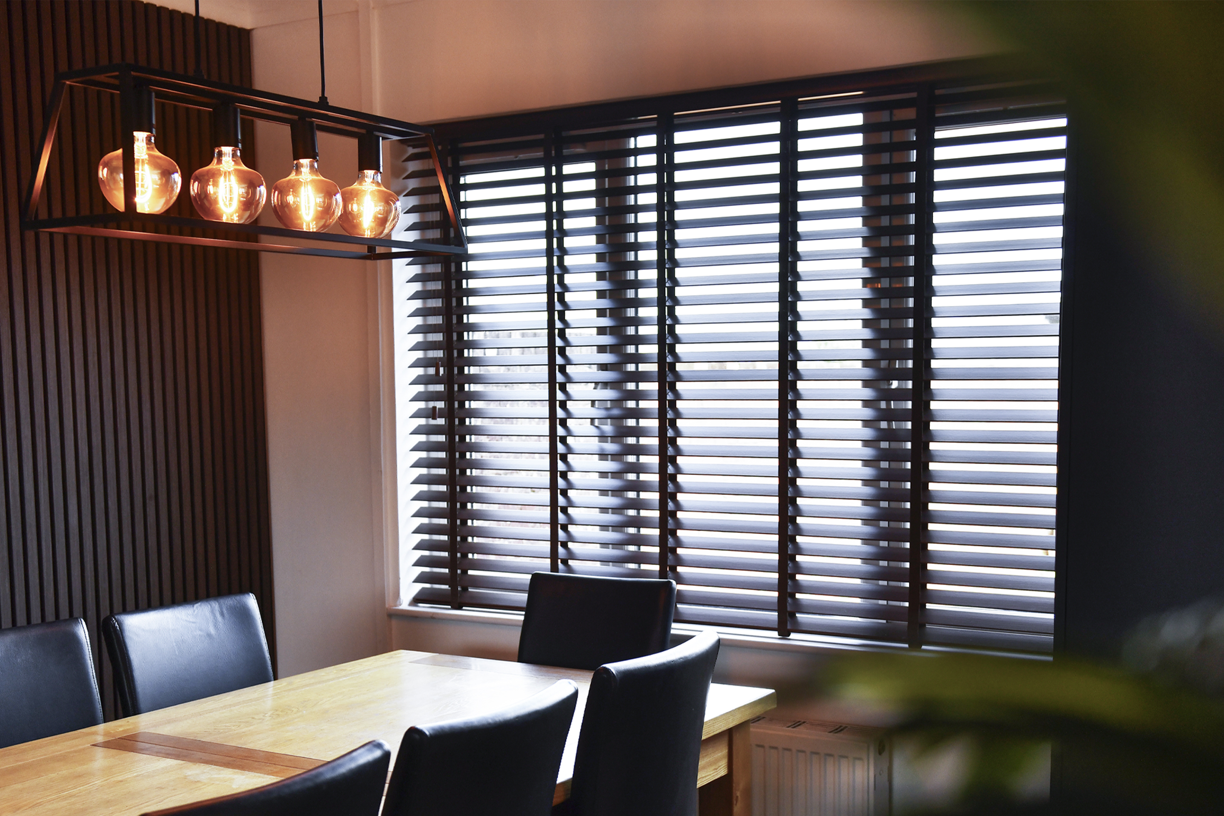 Decorquip dark faux wood Venetian blinds partially open in a modern dining room