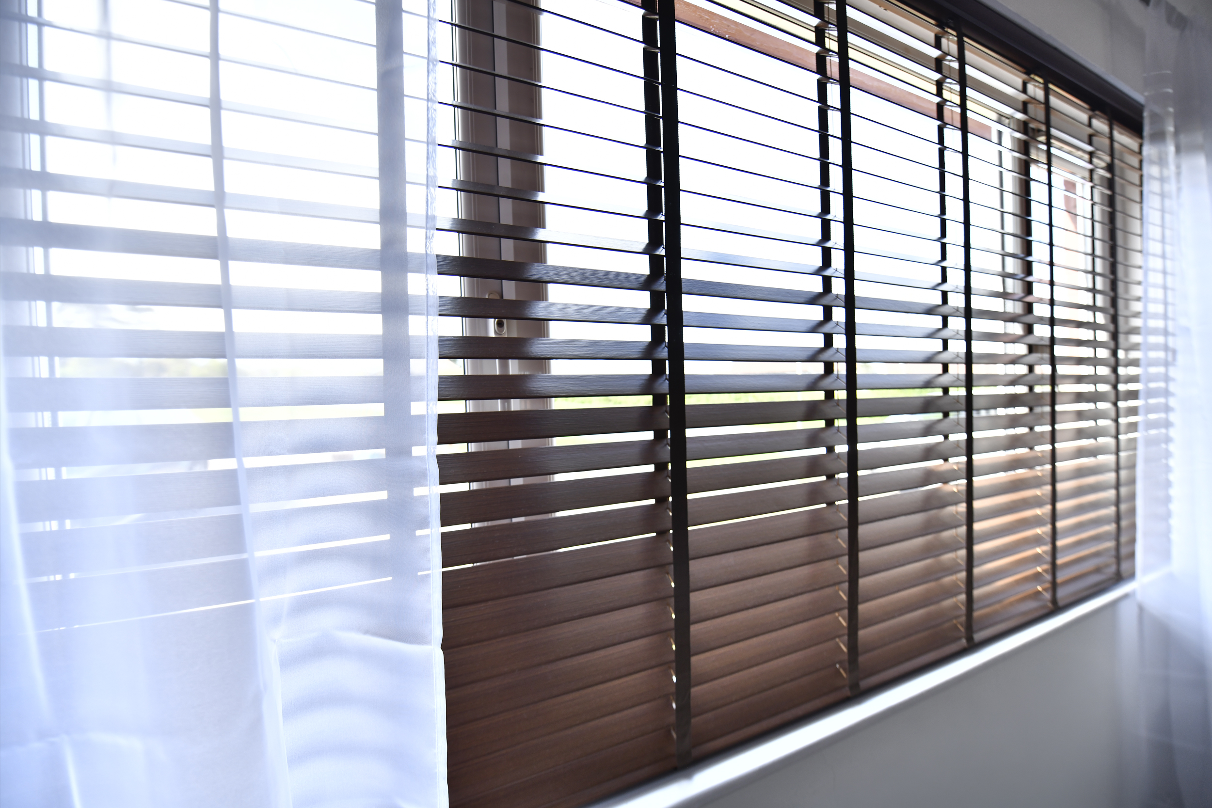 Decorquip dark faux wood Venetian blind fitted to a wide living room window