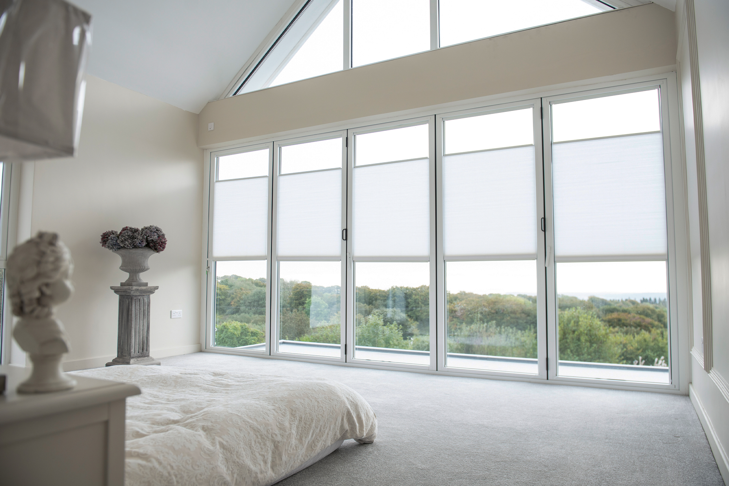 Decorquip white pleated blinds partially lowered across large bedroom windows