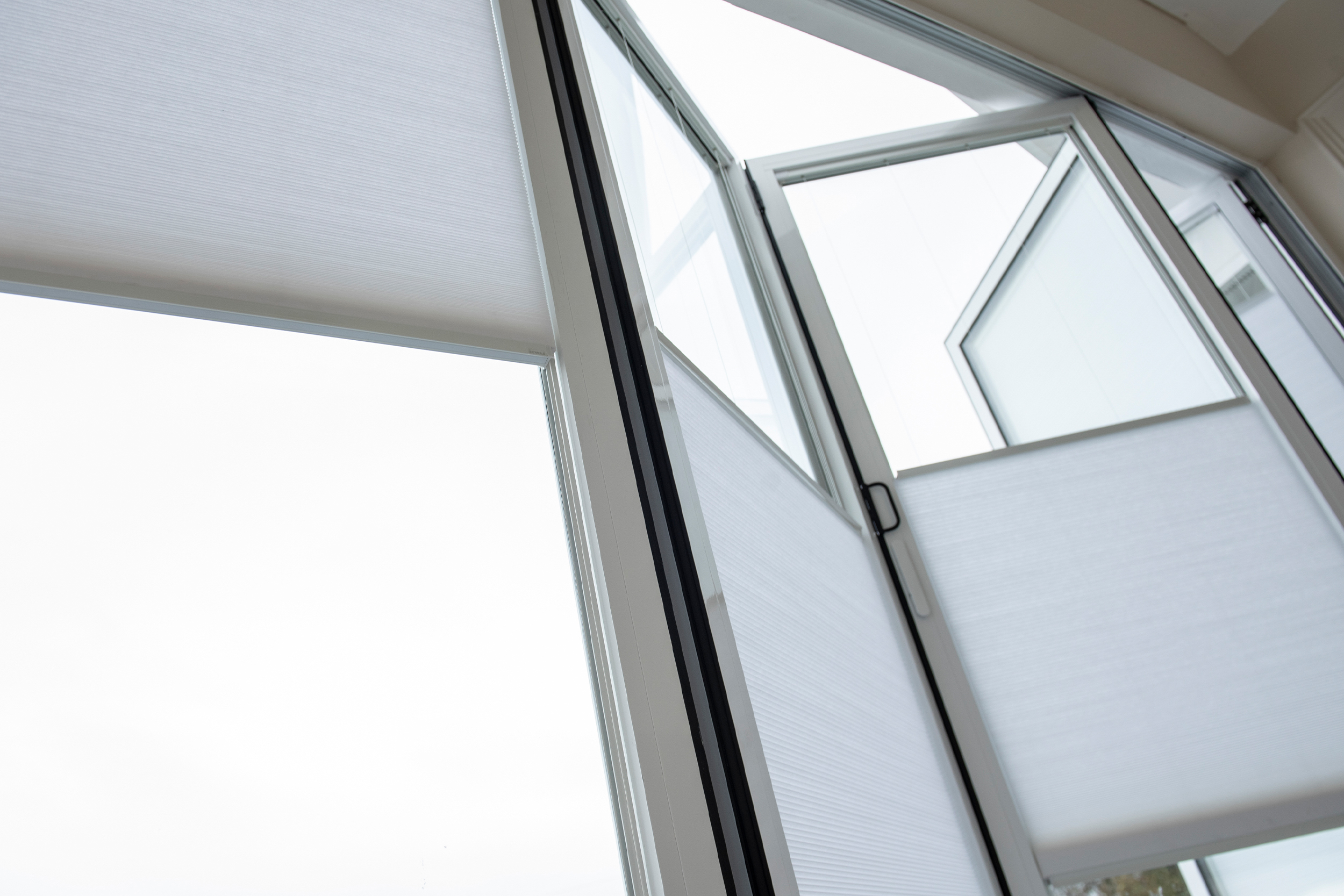 Decorquip white pleated blinds partially lowered across large bedroom windows