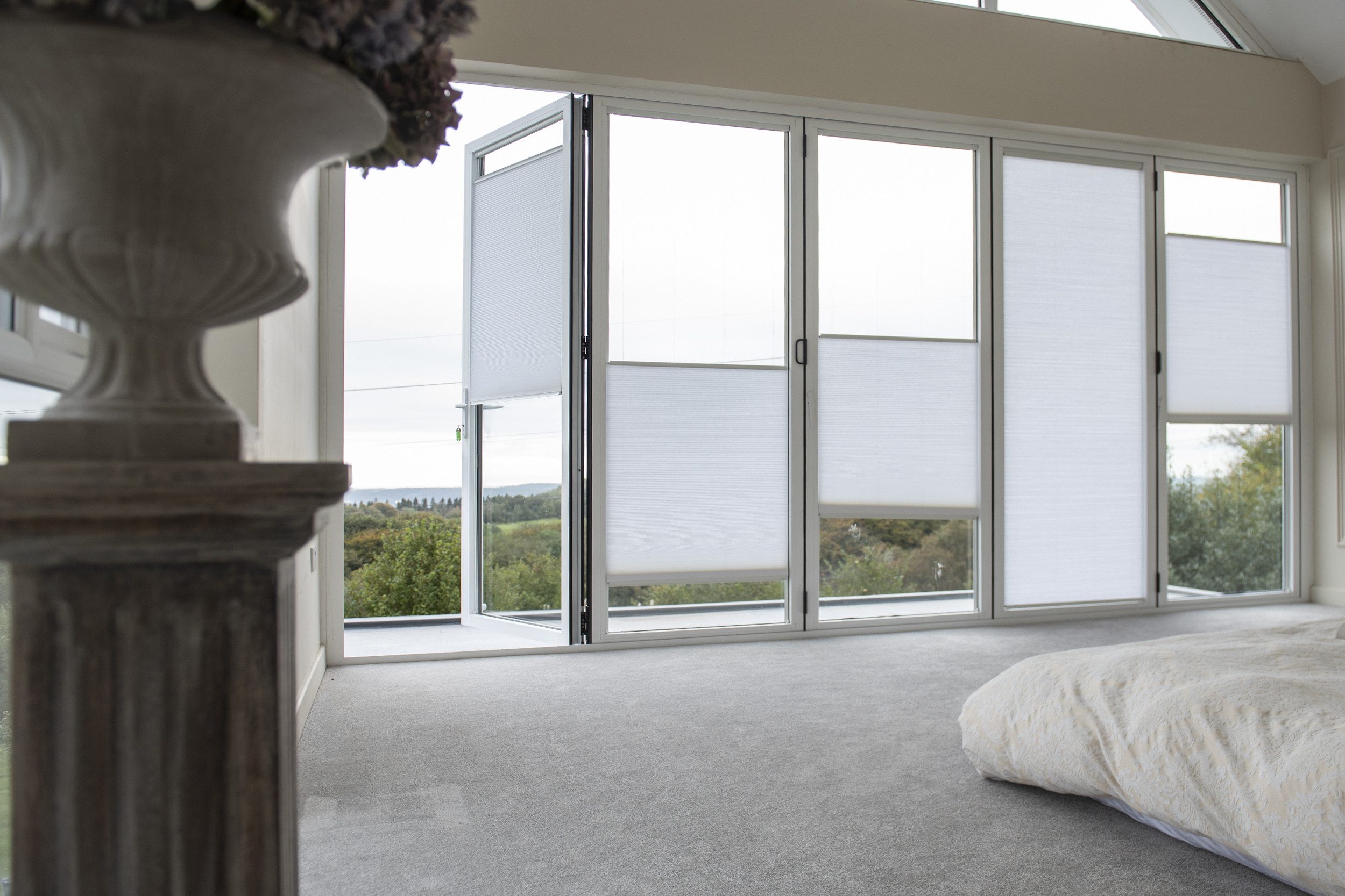Decorquip white pleated blinds partially lowered across large bedroom windows