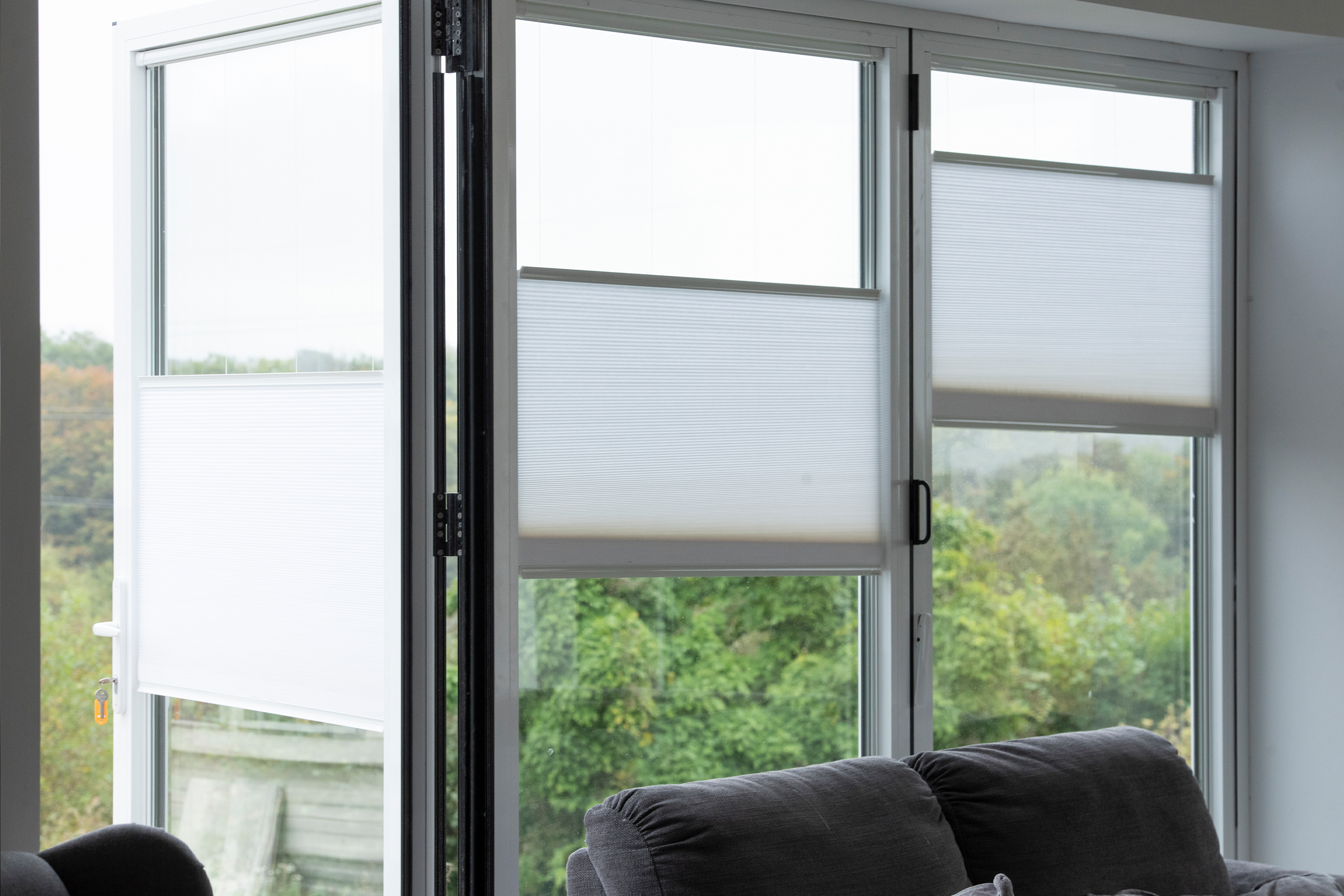 Decorquip white pleated blinds partially lowered on living room windows