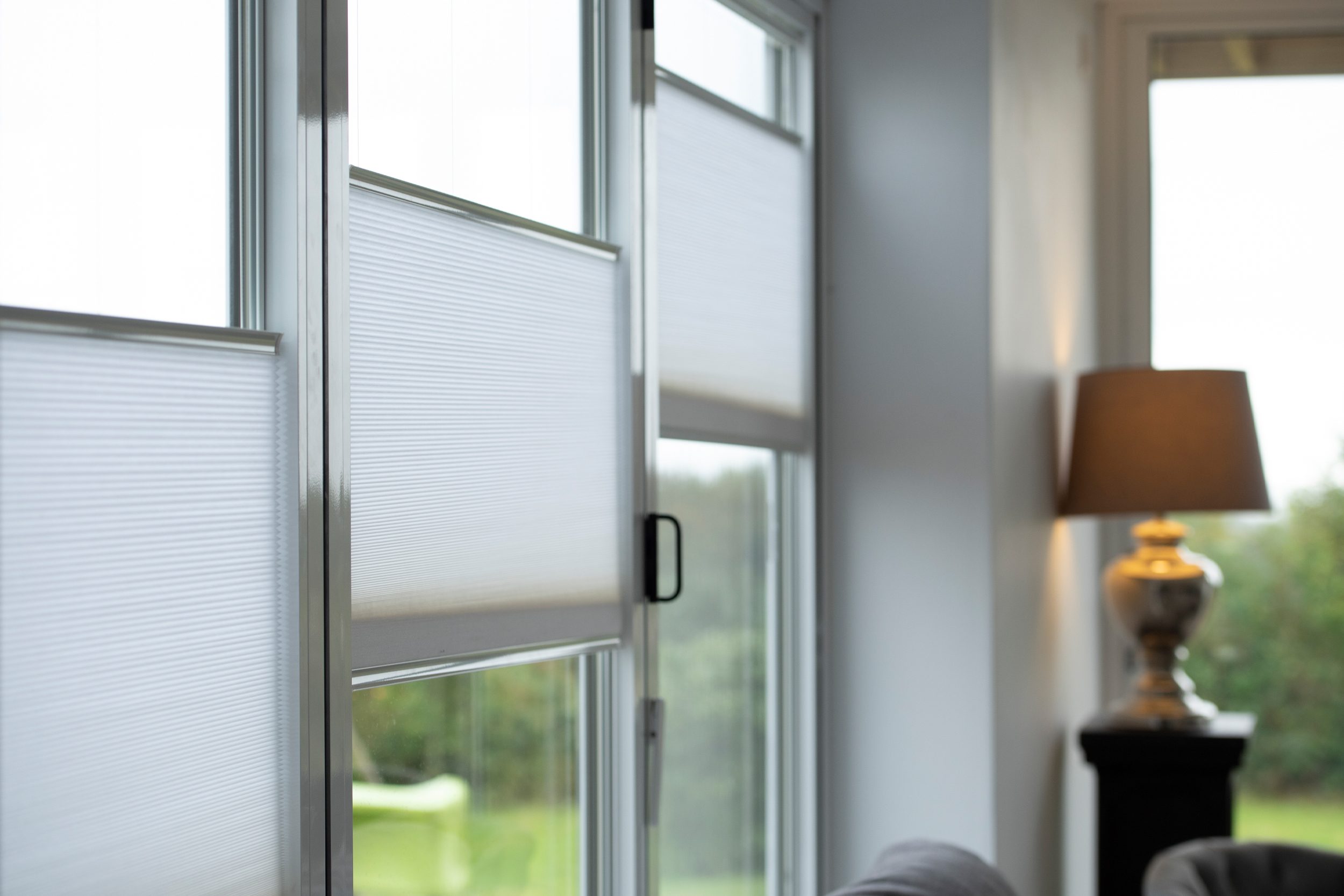 Decorquip white pleated blinds partially lowered on living room windows