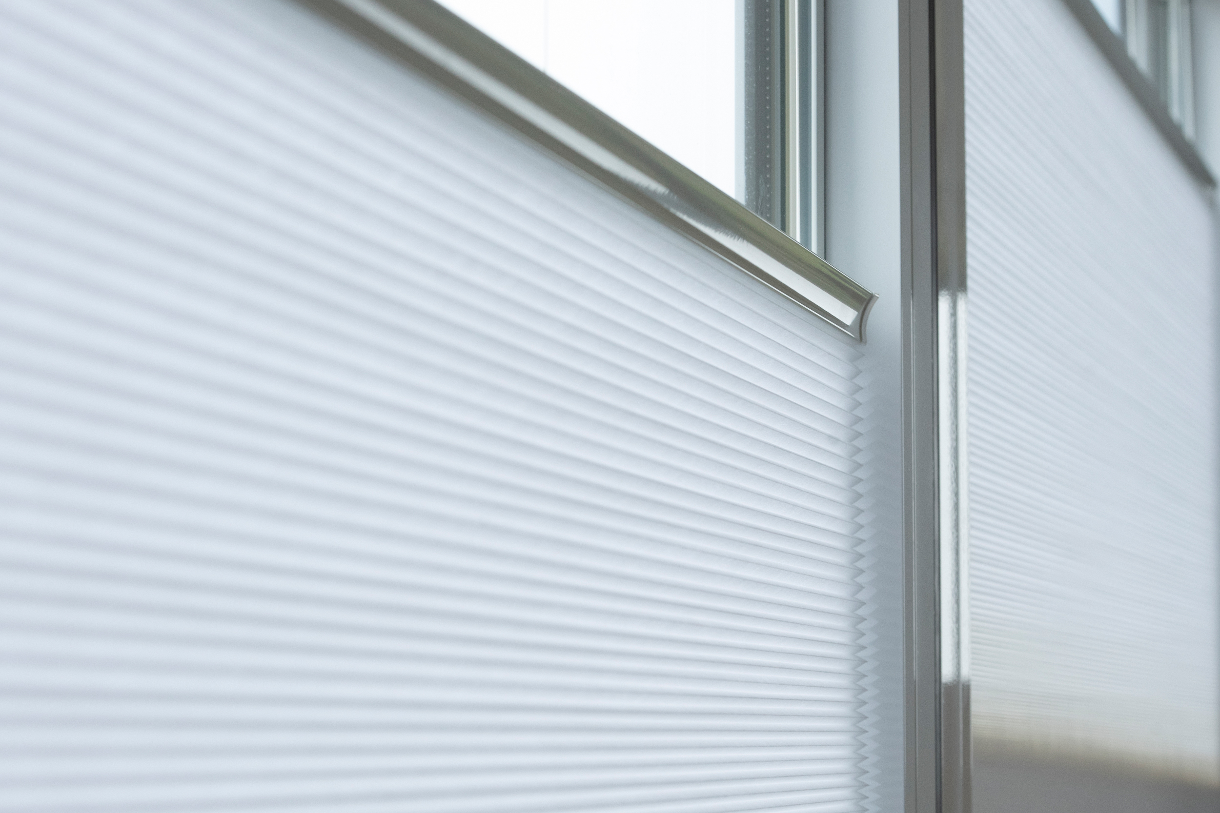 Decorquip white pleated blinds partially lowered on living room windows