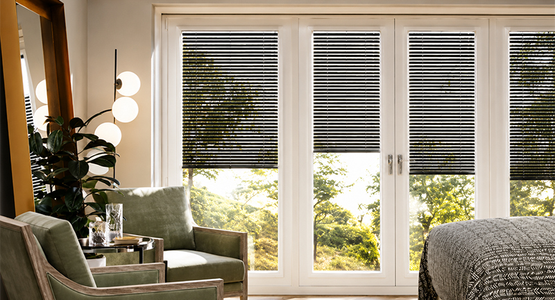 Decorquip black Perfect Fit Venetian blinds fitted to white French doors in a bedroom