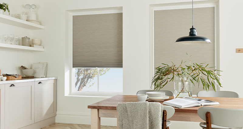 Decorquip grey Perfect Fit pleated blinds partially lowered in a bright kitchen dining area