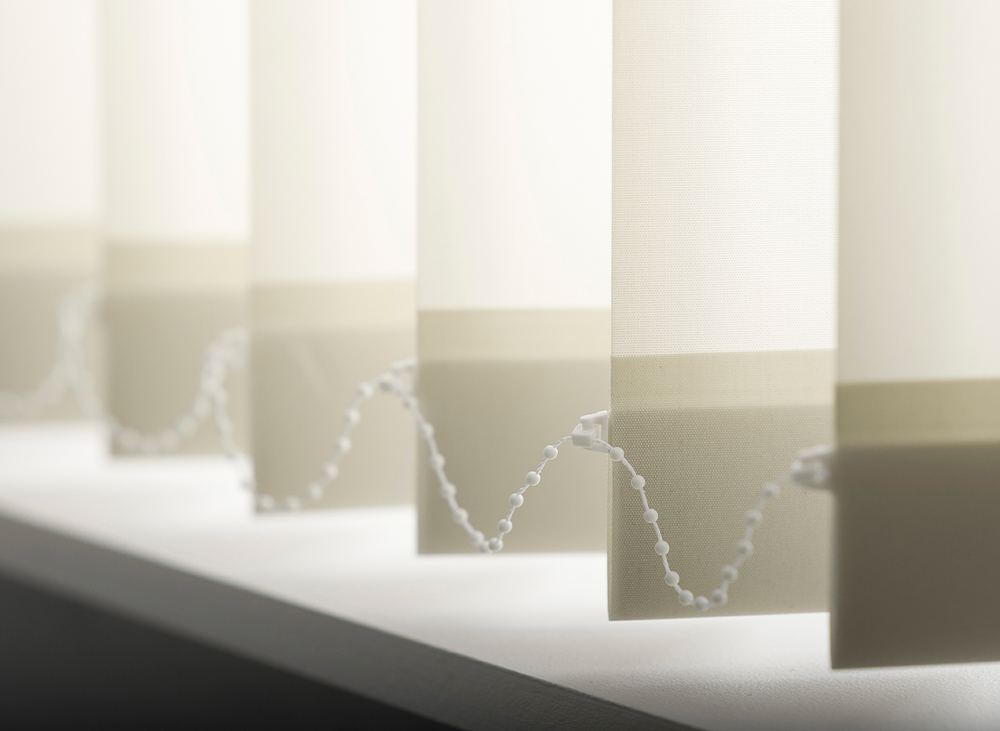 Decorquip cream vertical blind with translucent fabric louvres and bead chain in a bright interior setting